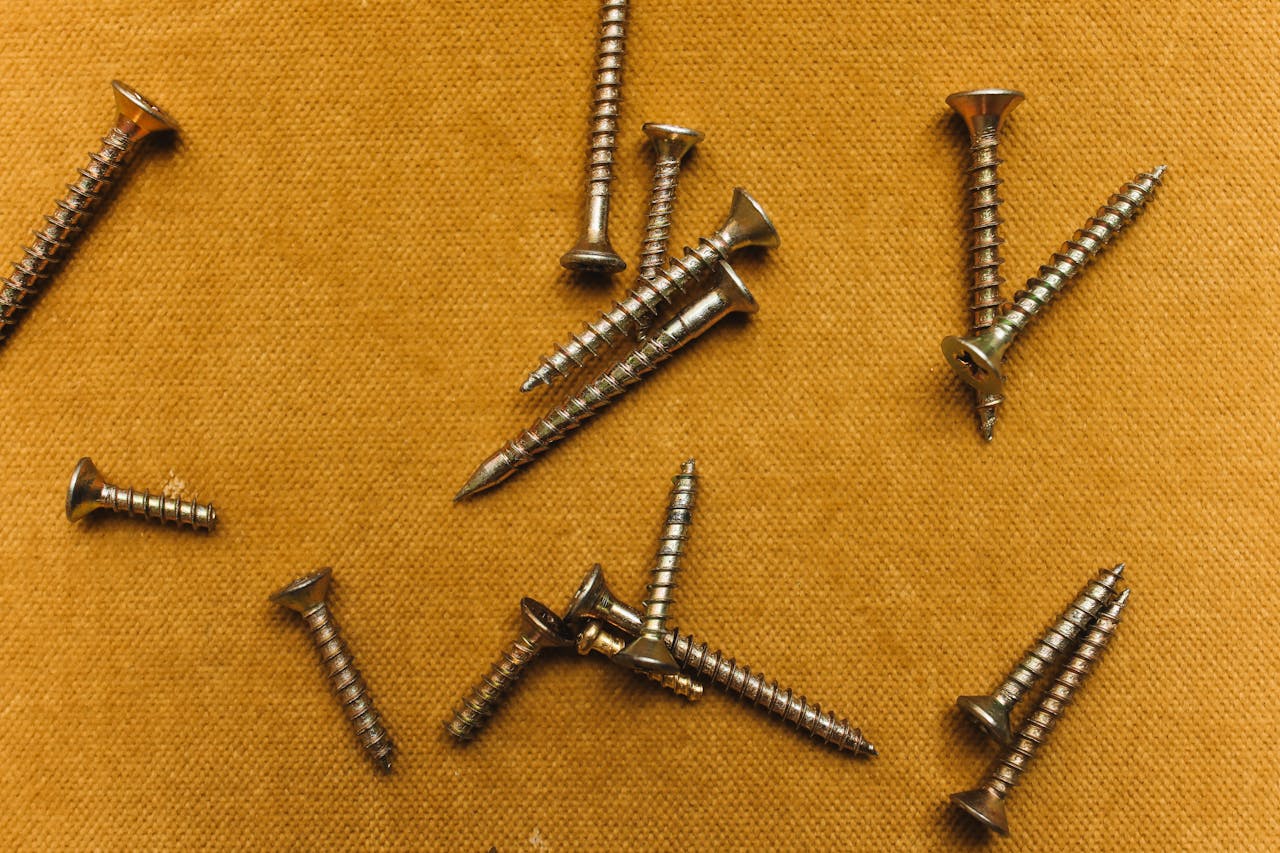 Crafting Captivating Headlines: Your awesome post title goes here Close-up of metal screws on textured brown fabric; overhead view.